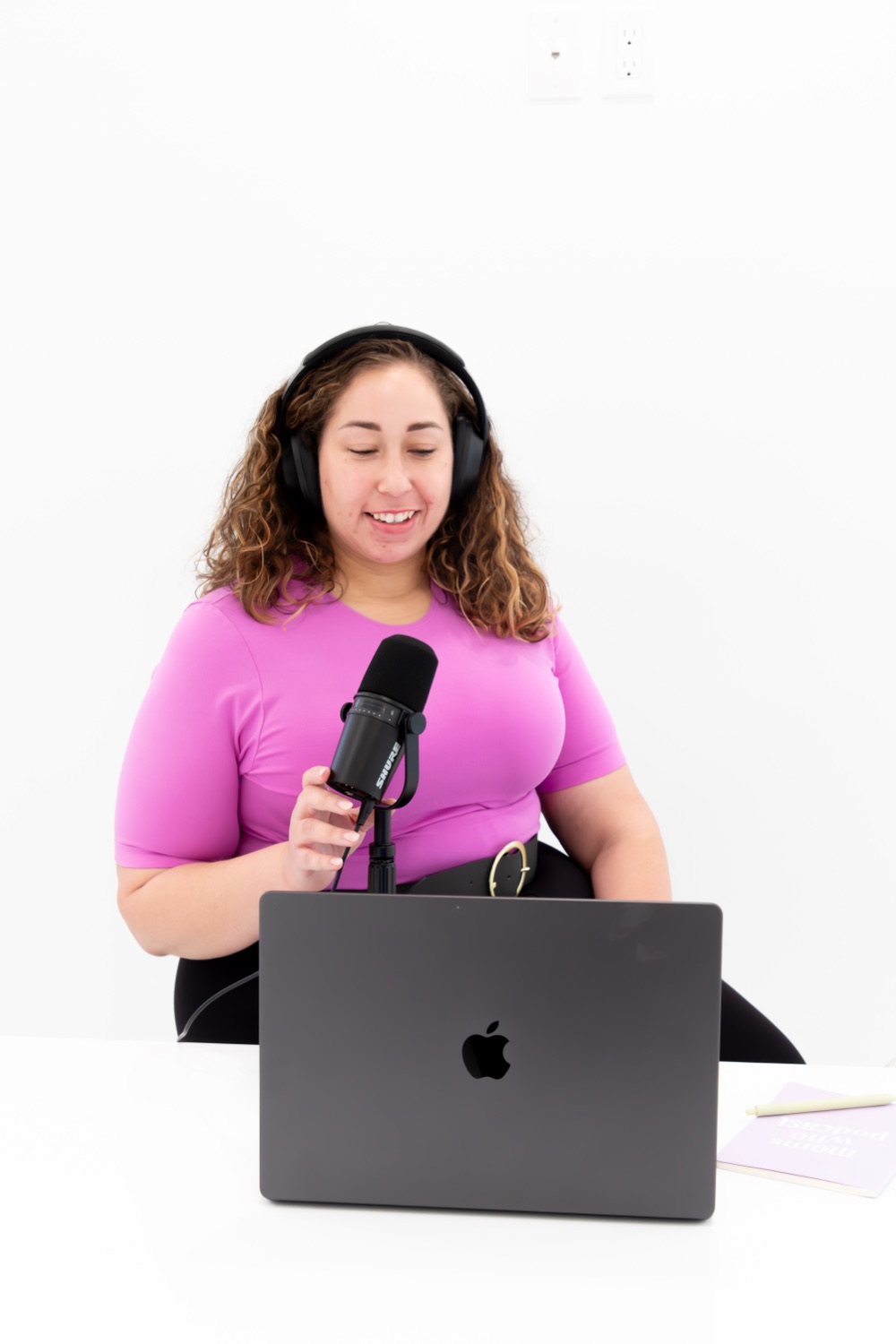Pamela Krista smiling at her mic with headphones on